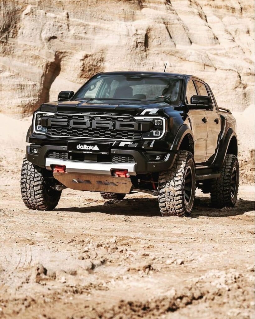 Black 2025 Ford Ranger Raptor parked on rugged desert terrain, showcasing its aggressive grille, off-road tires, and bold design.