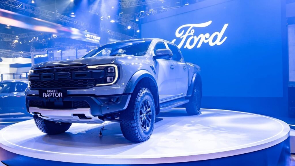 2025 Ford Ranger Raptor showcased on a circular platform with blue lighting and a Ford logo in the background